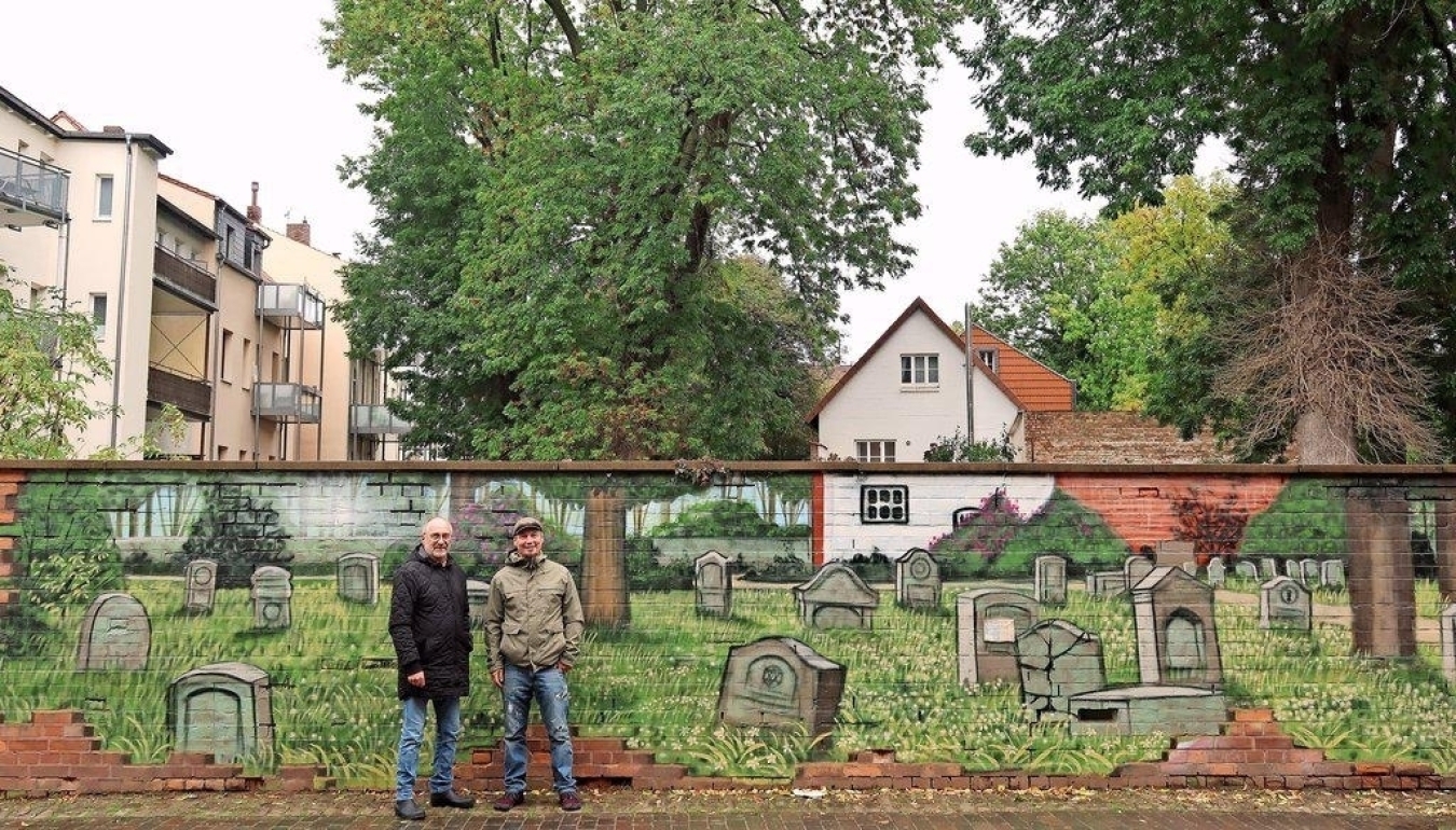 Das Graffito in der Teichstraße lässt scheinbar die Mauer verschwinden und zeigt den Jüdischen Friedhof dahinter.
Uwe Herwig und Ole Görgens freuen sich über die Neugestaltung. Foto: Wiebke Bart